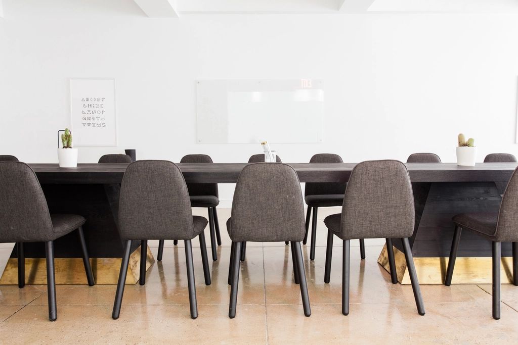 A meeting room with a long table and chairs